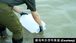 한국 원자력안전위원회 관계자가 우라늄 폐수 오염도 조사를 위한 시료 채취를 하고 있다.