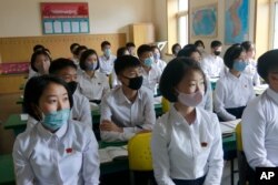 FILE - Students wearing face masks take a class at the Ryongwang Senior Middle School in Pyongyang, North Korea, June 3, 2020. After months of denying it had any coronavirus infections, North Korea reported its first suspected case July 25, 2020.