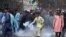 Supporters of Tehreek-e-Labiak Pakistan, a banned Islamist party, prepares to hurl back a tear gas canister fired by police to disperse protests over the arrest of their party leader Saad Rizvi, in Karachi, Pakistan, Monday, April 19, 2021.