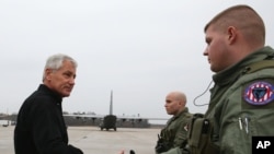 Menteri Pertahanan Amerika Serikat, Chuck Hagel menyapa dua tentara Angkatan Udara AS di Pangkalan Udara Militer Amerika, Andrews, di Maryland (5/12) sebelum keberangkatannya ke Afghanistan. 