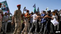 La police militaire égyptienne et les organisateurs bénévoles retiennent les manifestants lors d'une manifestation près du poste frontière de Rafah, le 20 octobre 2023.