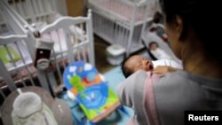 Seorang relawan merawat bayi di Seoul, Korea Selatan, 18 Desember 2018. Tingkat kesuburan Korea Selatan jeblok mencapai rekor terendah pada 2022. (Foto: Reuters)