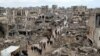 Palestinians walk past the rubble of buildings destroyed during the Israeli offensive, on a rainy day in Gaza City amid a ceasefire between Israel and Hamas, Feb. 6, 2025. 