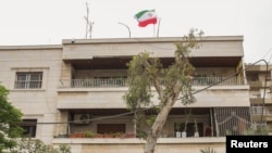 ธงชาติอิหร่านบนสถานกงสุลอิหร่านแห่งใหม่ประจำกรุงดามัสกัส ประเทศซีเรีย หลังสถานที่เดิมถูกโจมตีในวันที่ 1 เมษายน 2024 โดยอิหร่านอ้างว่าเป็นการโจมตีโดยอิสราเอล (ที่มา: Reuters)