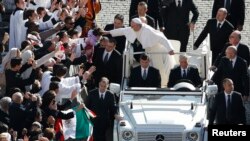 Pope Francis leans out to touch a child's head as he arrives in Saint Peter's Square for his inaugural mass at the Vatican, March 19, 2013. (REUTERS PHOTO)