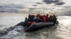 FILE - Migrants board a smuggler's boat in an attempt to cross the English Channel near Dunkirk, France, April 26, 2024. Several people, including a child, died trying to cross the English Channel from France to England, French Interior Minister Bruno Retailleau said Saturday. 