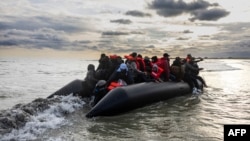 FILE - Migrants board a smuggler's boat in an attempt to cross the English Channel near Dunkirk, France, April 26, 2024. Several people, including a child, died trying to cross the English Channel from France to England, French Interior Minister Bruno Retailleau said Saturday. 