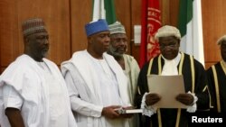 Bukola Saraki (2nd L) takes the oath of office as the senate president of the 8th Nigeria Assembly in Abuja, Nigeria June 9, 2015. Also pictured are Senator Dino Melaye (L), Senator Sani Yerima and National Assembly Clerk Salisu Maikasuwa (R). REUTERS/Af