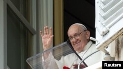 El papa Francisco saluda a la multitud reunida en la Plaza de San Pedro del Vaticano durante el rezo del Ángelus el 27 de agosto de 2023.