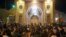 People gather outside the closed doors of the Fatima Masumeh shrine in Iran's holy city of Qom, March 16 2020. 
