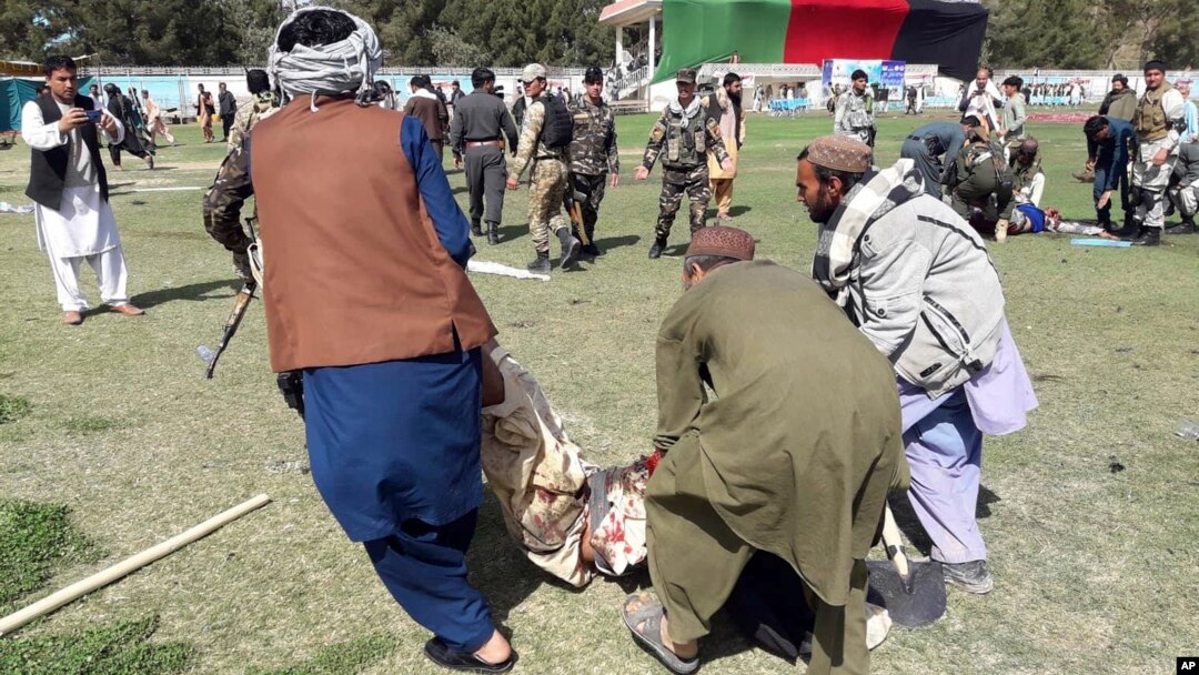 A wounded man is carried away following explosions at an agrucultural show in Lashkar Gah, Helmand province, southern Afghanistan, March 23, 2019.