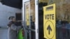 FILE - Signs point voters to a polling station in Burnaby, British Columbia, Canada, Feb. 25, 2019. An official commission is about to get underway in Ottawa as Canada tries to determine to what extent China and other countries interfered in its last two elections. 