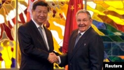 资料照 - 2014年7月22日，时任古巴总统劳尔·卡斯特罗(Raul Castro)(右)同中国国家主席习近平在古巴首都哈瓦那的革命宫会晤前握手。