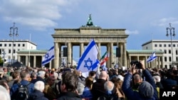 Demonstran mengibarkan bendera Israel saat menghadiri unjuk rasa solidaritas dengan Israel di Berlin, Jerman, Minggu 22 Oktober 2023. 