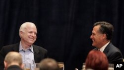 Mantan Gubernur Massachusetts Mitt Romney bercanda dengan Senator John McCain dalam sebuah acara di Scottsdale, Jumat (20/4).