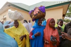 A mother reacts as she receives her daughter after she arrived along with other rescued JSS Jangebe schoolgirls in Jangebe, Zamfara, Nigeria, March 3, 2021.