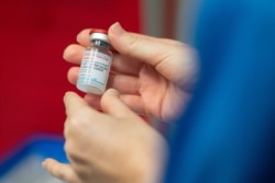 A nurse holds a vial of the Moderna coronavirus disease (COVID-19) vaccine at the Glangwili General Hospital in Carmarthen, Wales, Britain, April 7, 2021. (Jacob King/Pool via Reuters)