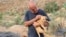 In this photo provided by Mashala Shelter, Hussein Hamza carries a puppy at his animal shelter in Kfour, south Lebanon in 2024. (Mashala Shelter via AP)
