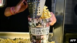 Una persona se sirve palomitas de maíz en el teatro AMC Century City, en Century City, California, el 12 de octubre de 2023, antes de ver la película de la cantante Taylor Swift.