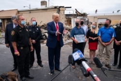 FILE - President Donald Trump tours an area on Sept. 1, 2020, damaged during demonstrations after a police officer shot Jacob Blake in Kenosha, Wis.