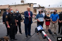 FILE - President Donald Trump tours an area on Sept. 1, 2020, damaged during demonstrations after a police officer shot Jacob Blake in Kenosha, Wis.