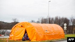 FILE - A girl enters a the temporary reception center for refugees at Storskog border station near Kirkenes in northern Norway at the Norway-Russia border, on Oct. 13, 2015. 