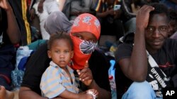 FILE - Migrants sit during a gathering in Sfax, Tunisia's eastern coast, Friday, July 7, 2023. 