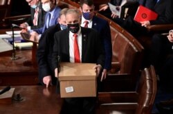 FILE - Electoral College ballot boxes arrive to a joint session of the Congress to certify the 2020 election results on Capitol Hill in Washington, Jan. 6, 2021.