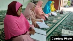 Perempuan dengan disabilitas sensorik di Kota Medan, Sumatra Utara, sedang membaca Alquran braille. (Courtesy: Persatuan Tunanetra Indonesia atau Pertuni)