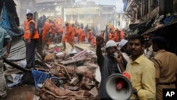 Les secours recherchent des survivants et tentent de dégager les corps de victimes après l’effondrement d’un immeuble à Bombay, Inde, le 31 août 2017. 