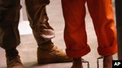 A 'non-compliant' detainee is escorted by guards after showering inside the U.S. military prison for 'enemy combatants' in Guantanamo Bay, Cuba, 27 Oct 2009.