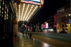 An empty Hollywood Boulevard is seen under the neon lights of El Capitan Theatre, top left, on April 2, 2020, in Los Angeles.