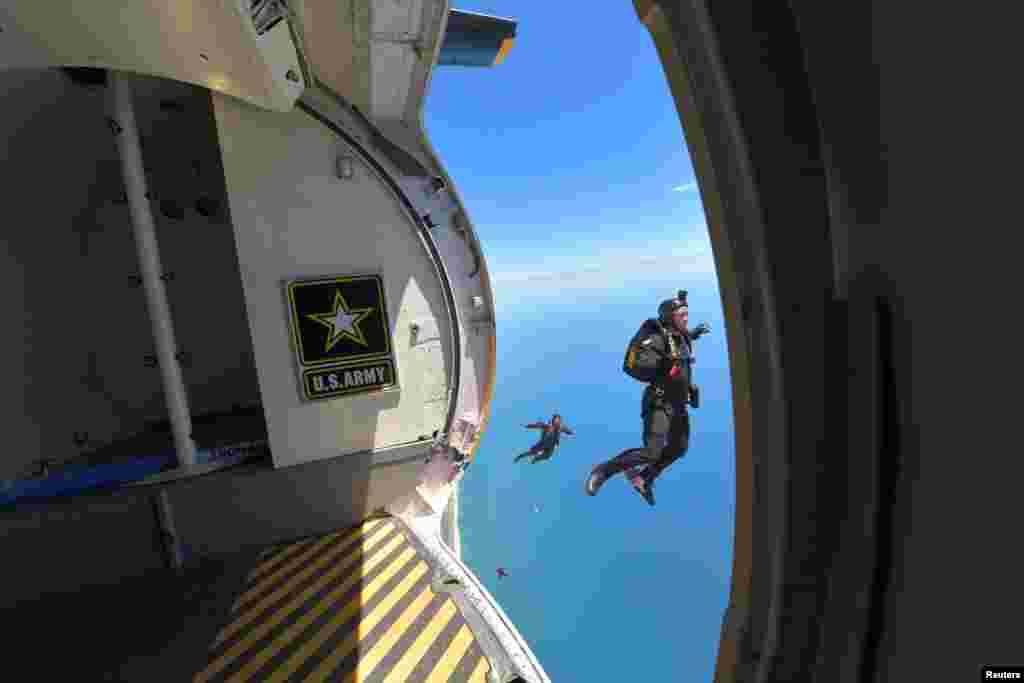 میموریل ڈے کی تقریبات کے سلسلے میں پیراٹروپرز ایک طیارے سے چھلانگ لگا رہے ہیں۔