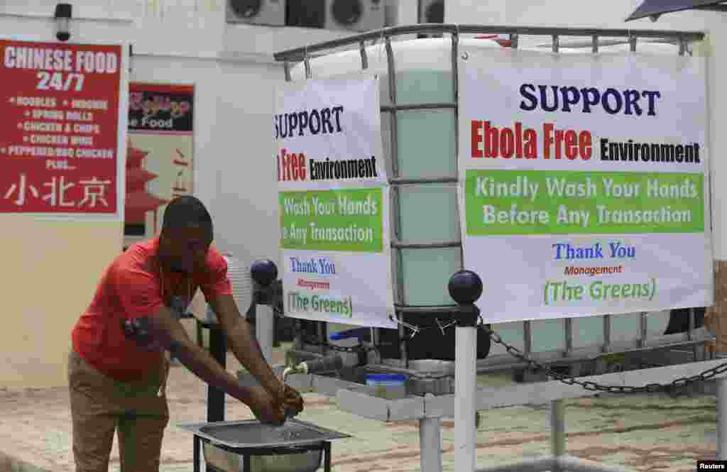 A man washes his hands at a tap outside the Green Pharmacy at Area 8 in Abuja, Sept. 1, 2014.