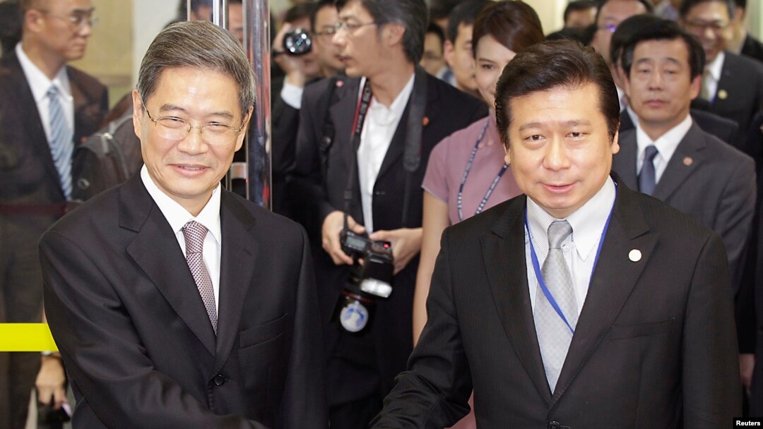 Zhang Zhijun (kiri), yang memimpin kantor urusan Taiwan di China, bersalaman dengan mitranya di Taiwan, Wang Yu-Chi (25/6).