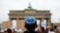 FILE - A man wearing a Jewish scullcap waits for the start of an anti-Semitism rally at Berlin's Brandenburg Gate, in Berlin, Germany Sept. 14, 2014.