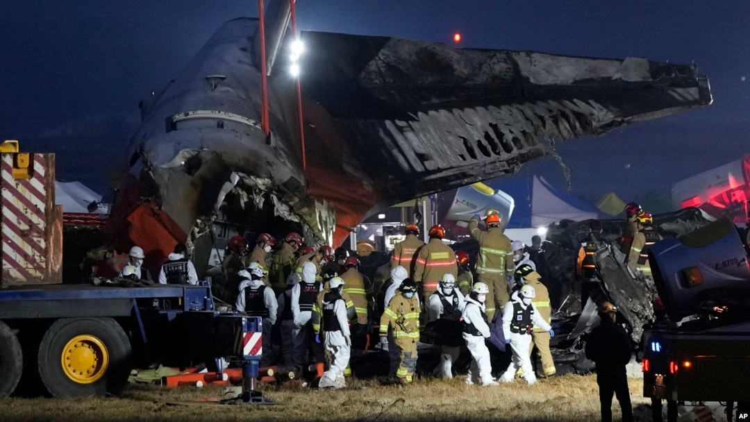 Rescue team carry the body of a passenger at the site of a plane fire at Muan International Airport in Muan, South Korea, Dec. 29, 2024. 