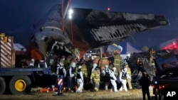 Rescue team carry the body of a passenger at the site of a plane fire at Muan International Airport in Muan, South Korea, Dec. 29, 2024. 