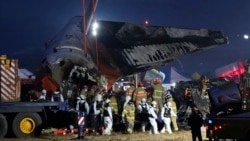 Rescue team carry the body of a passenger at the site of a plane fire at Muan International Airport in Muan, South Korea, Dec. 29, 2024. 