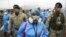 Les agents de santé sont escortés par des soldats lors d'une campagne de dépistage du COVID-19 porte-à-porte dans le bidonville Villa Maria del Triunfo de Lima, au Pérou, le mardi 12 janvier 2021. (Photo AP / Martin Mejia)