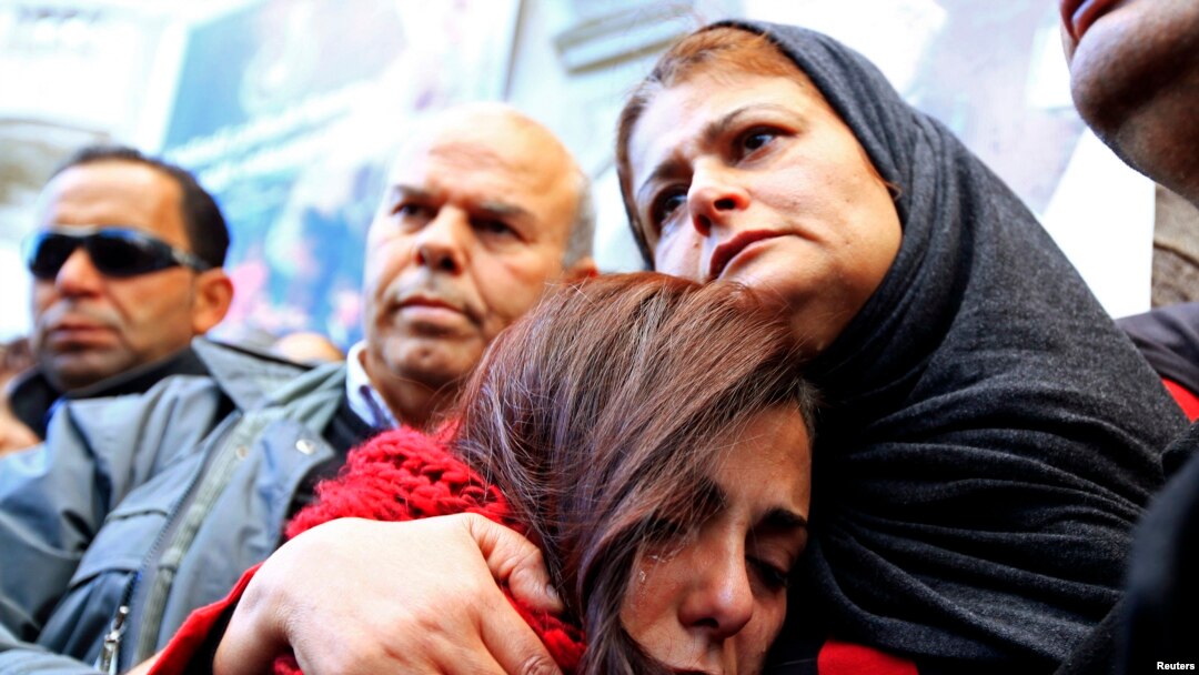 The mother, right, of photographer Nadhir Ktari, who disappeared with fellow journalist Sofiene Chourabi in Libya in September, attends a demonstration held in solidarity with the missing pair in Tunis, Jan. 9, 2015.