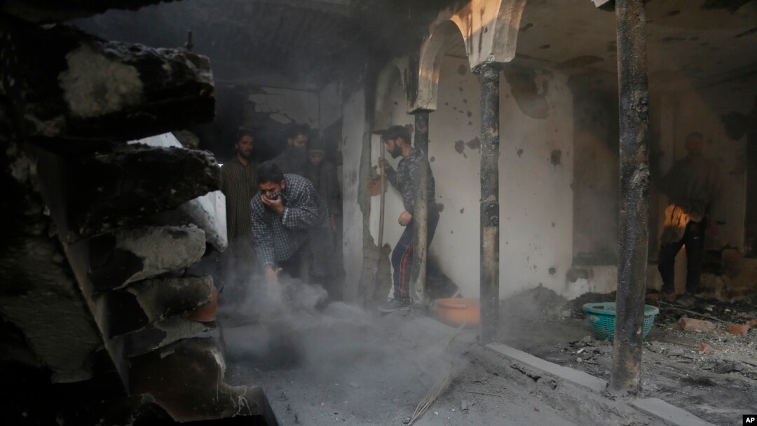 Kashmiri Muslim villagers clean the debris of a house which was damaged in a gunbattle at Shopian, south of Srinagar, Indian controlled Kashmir, Tuesday, Nov. 20, 2018.