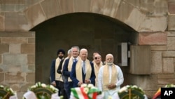 El presidente estadounidense Joe Biden, centro izquierda, con el primer ministro indio Narendra Modi, derecha, y otros líderes del G20 llegan para presentar sus respetos al Rajghat, un monumento a Mahatma Gandhi, en Nueva Delhi, India, el domingo 10 de septiembre de 2023.