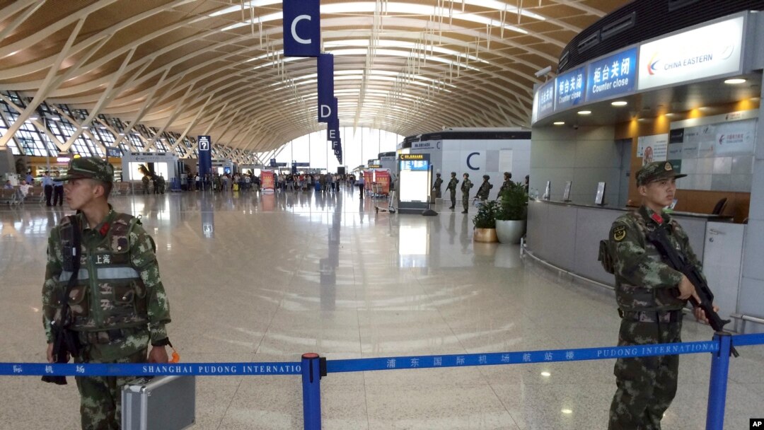 Polisi berjaga-jaga di bandara internasional Shanghai setelah terjadi ledakan.