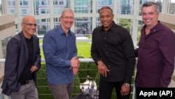 From left, music entrepreneur and Beats co-founder Jimmy Iovine, Apple CEO Tim Cook, Beats co-founder Dr. Dre, and Apple senior vice president Eddy Cue pose together at Apple headquarters in Cupertino, Calif., May 28, 2014. 