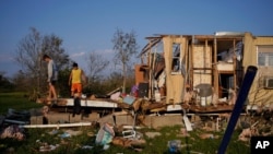 Aiden Locobon, left, and Rogelio Paredes look through the remnants of their family's home, destroyed by Hurricane Ida, Sept. 4, 2021, in Dulac, La.
