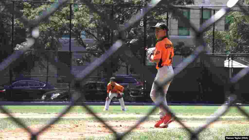 Ian Morales, murid kelas enam yang cemerlang, melempar bola untuk tim Cooper Pilots dalam program Field of Dreams dari Harlem RBI (12/8).