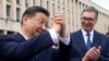 This handout photograph taken and released by Serbia's Presidential press service on May 8, 2024, shows Chinese President Xi Jinping (L), accompanied by Serbian President Aleksandar Vucic, greeting the people gathered outside the Palace of Serbia during a