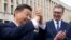 This handout photograph taken and released by Serbia's Presidential press service on May 8, 2024, shows Chinese President Xi Jinping (L), accompanied by Serbian President Aleksandar Vucic, greeting the people gathered outside the Palace of Serbia during a
