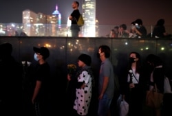 People line up to pay tribute at Tamar Park, outside the Legislative Council (Legco) building, during a prayer and remembrance ceremony in Hong Kong, China, Nov. 9, 2019.